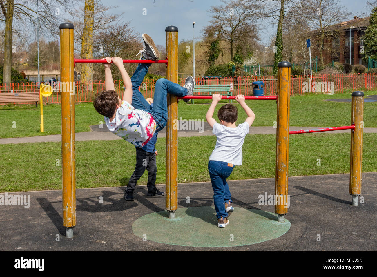 Les jeunes enfants jouer sur tirer la barre dans une aire de jeux pour enfants au centre du village de tonne près de Wolverhampton. Banque D'Images