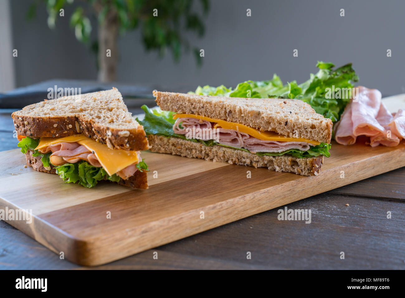 Panneaux sandwich au jambon et au fromage sur pain de blé entier on Cutting Board Banque D'Images