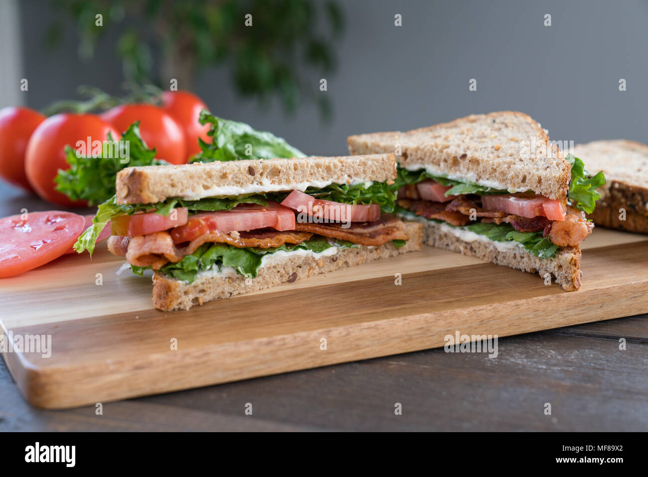 Bacon, laitue fraîche et tomate Sandwich sur une planche à découper Banque D'Images