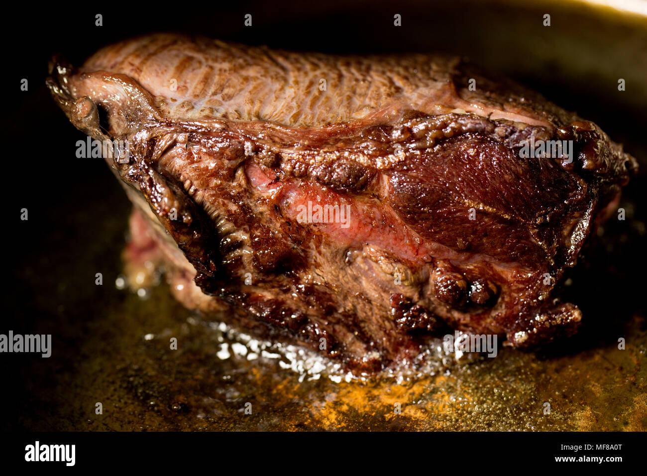 Un bœuf joue dans un supermarché d'être rissolées dans une poêle en cuivre avant d'être placés dans une cocotte avec un mélange de légumes, d'herbes et d'un bouillon de boeuf Banque D'Images