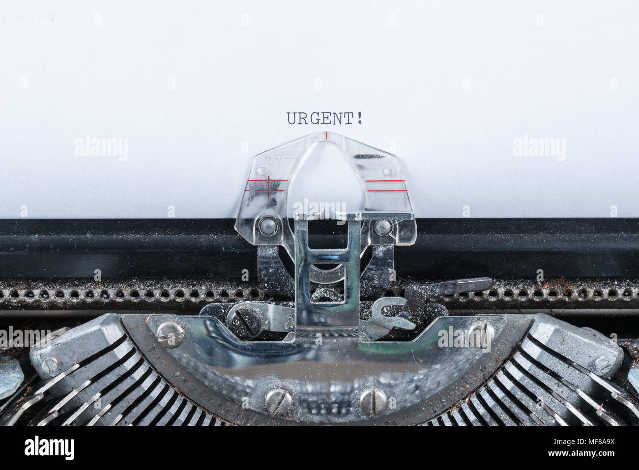 Texte tapé urgent sur une vieille machine à écrire Banque D'Images