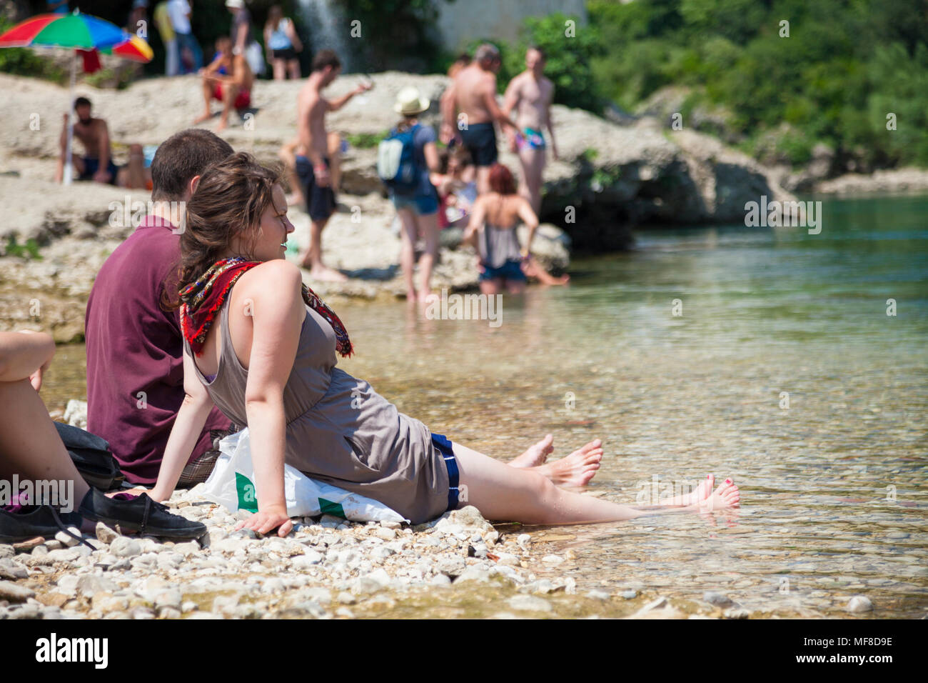 Les touristes se détendre au bord de la côté de la rivière Neretva près le Stari Most, le Vieux Pont de Mostar, Bosnie-Herzégovine Banque D'Images