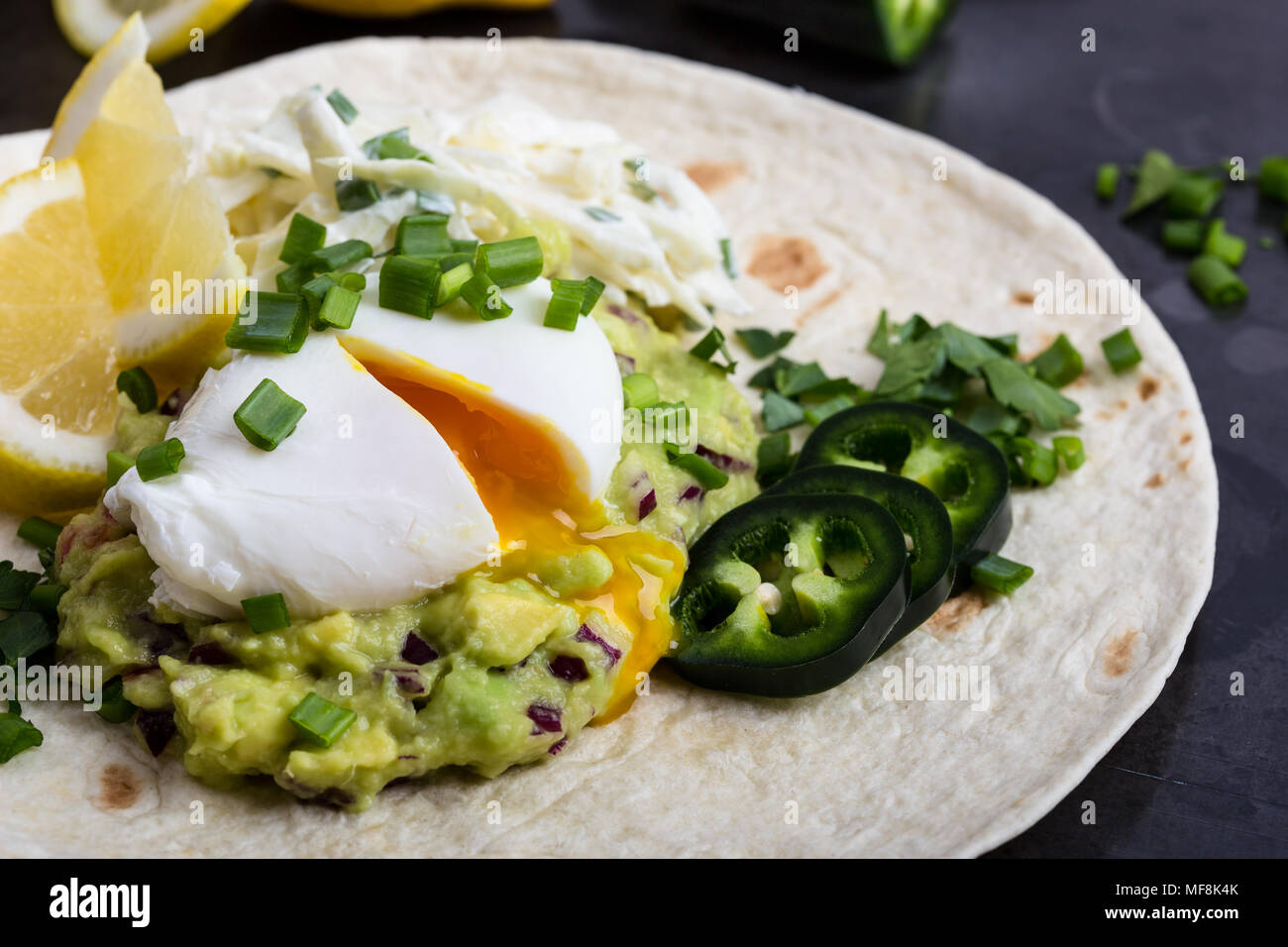 L'œuf poché sauce guacamole et tortilla de farine, le petit-déjeuner de style mexicain Banque D'Images