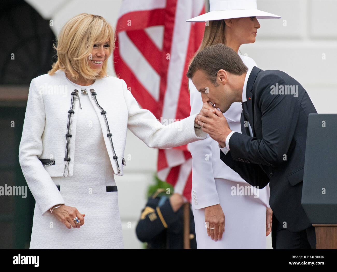 Le Président Emmanuel Macron de France bisous la main de sa femme, Brigitte Macron, à l'issue d'une cérémonie d'arrivée sur la pelouse Sud de la Maison Blanche à Washington, DC le mardi 24 avril 2018. Première dame Melania Trump est représenté derrière eux. Credit : Ron Sachs/CNP /MediaPunch Banque D'Images