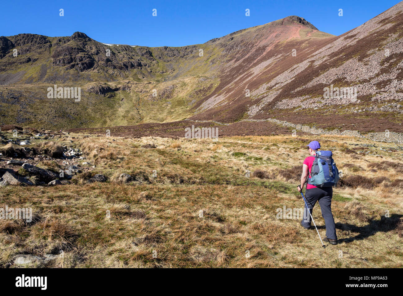 Walker s'approchant sur le brochet rouge Chemin Bois Burtness Bleaberry Tarn, près de Buttermere, Lake District, Cumbria, Royaume-Uni Banque D'Images