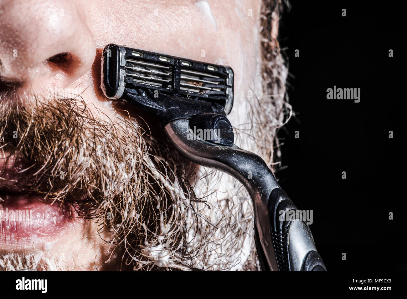 Dans l'homme se rase la mousse à raser la barbe et la moustache avec un  rasoir, photo close-up Photo Stock - Alamy