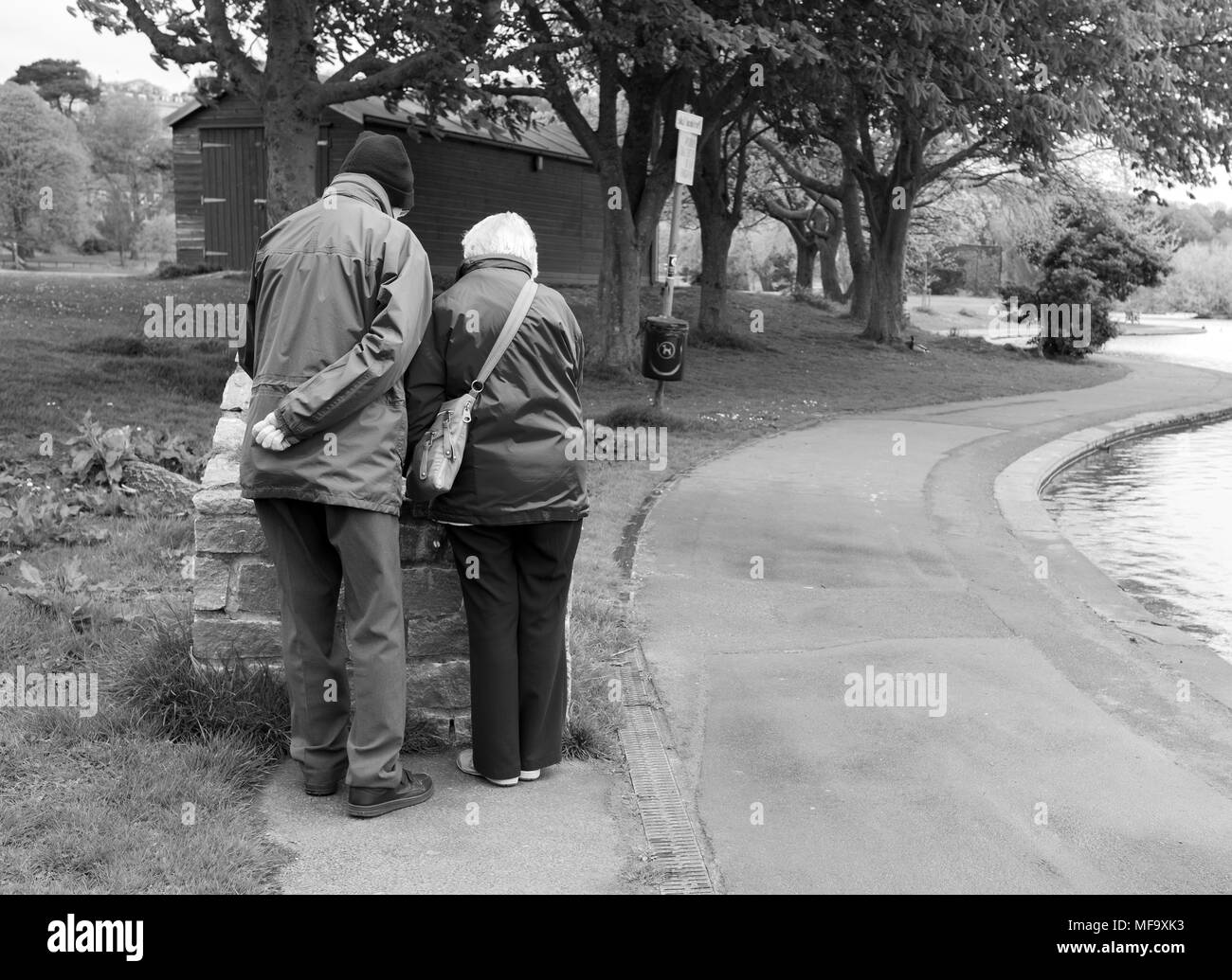 Avril 2018 - Mature couple checking out un panneau d'information dans un parc public. Banque D'Images