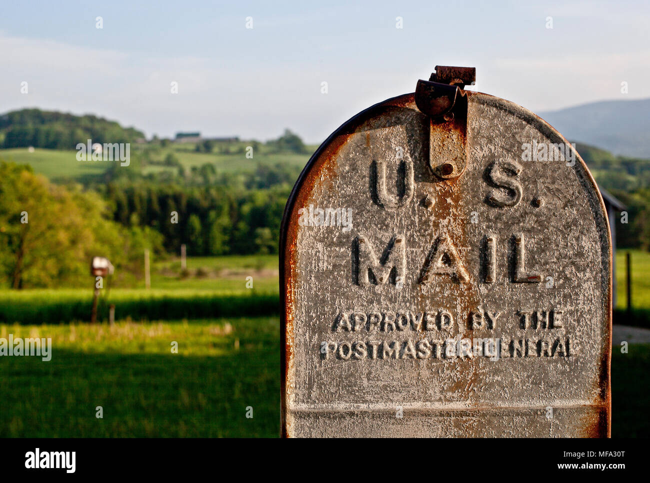 Vieux classique sur une boîte aux lettres rouillée Vermont ferme en face d'une très belle prairie Banque D'Images