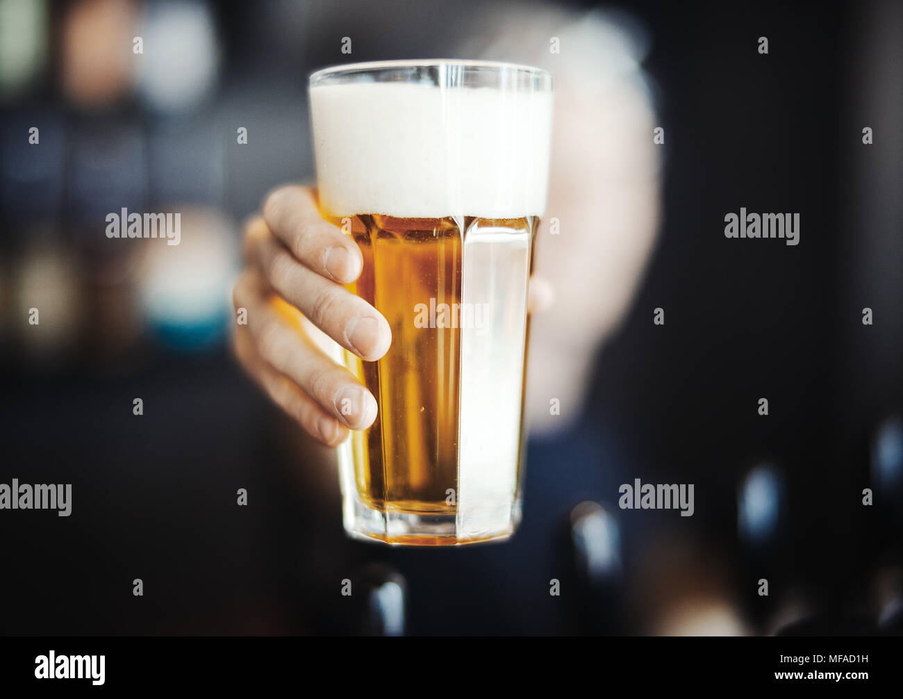 Barman, s'étend à l'homme un verre de bière. Banque D'Images