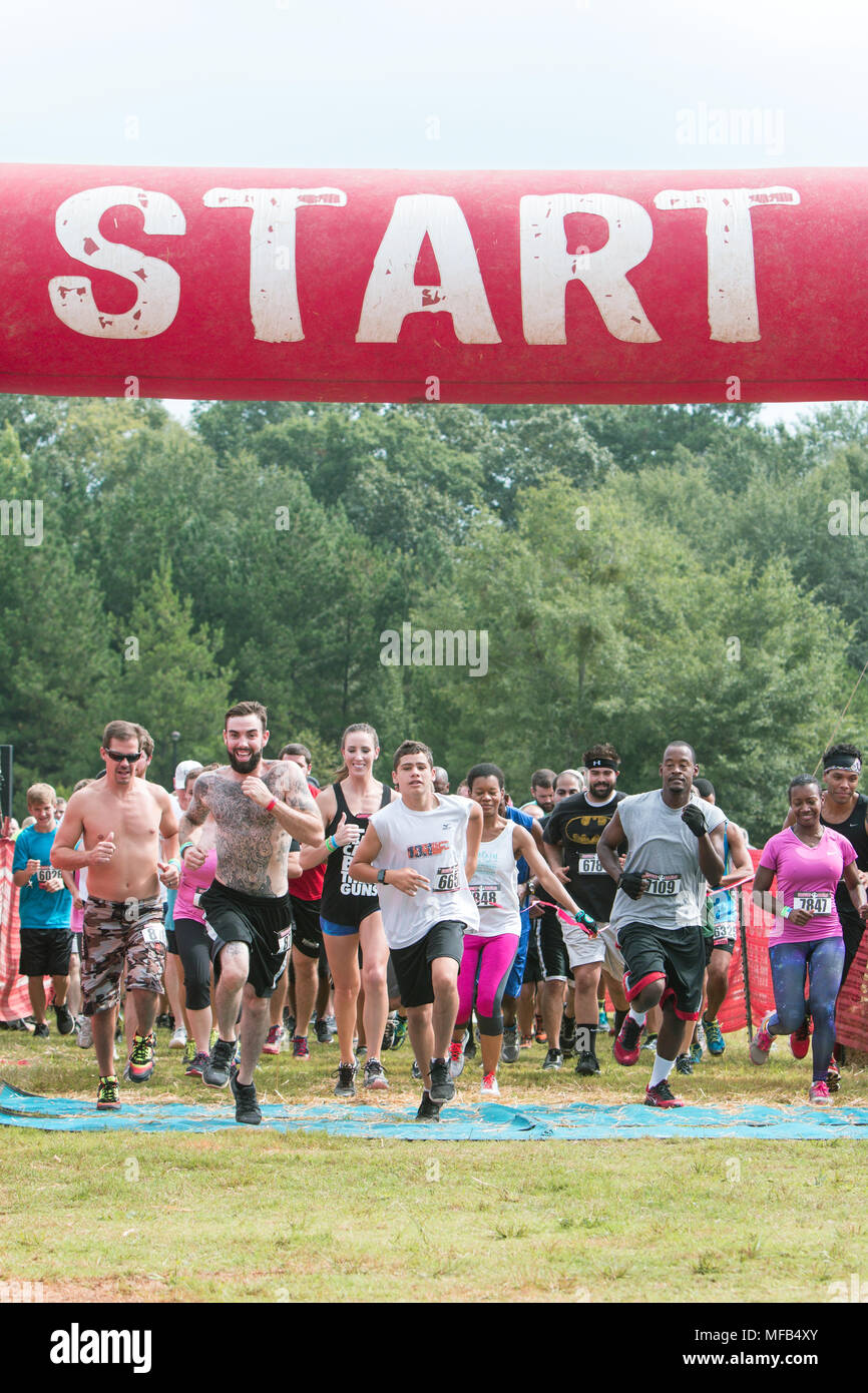 Un paquet de coureurs prend son envol à partir de la ligne de départ à l'événement Course à obstacles robuste Maniac le 22 août 2015 à Conyers, GA. Banque D'Images