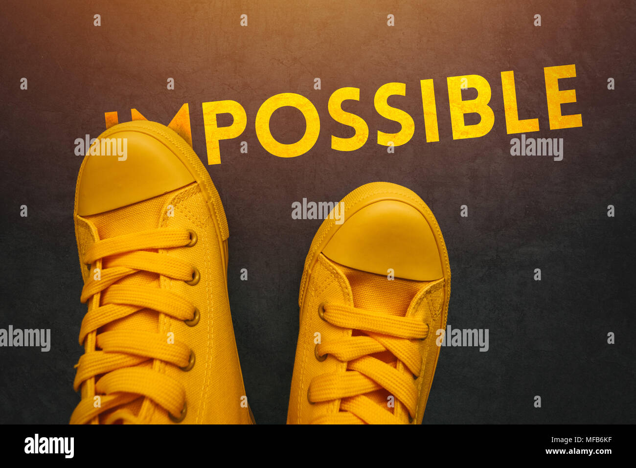 Les jeunes peuvent faire des choses possibles, conceptual image avec personne en jaune sneakers couvrant une partie du mot impossible pour qu'il change complètement i Banque D'Images