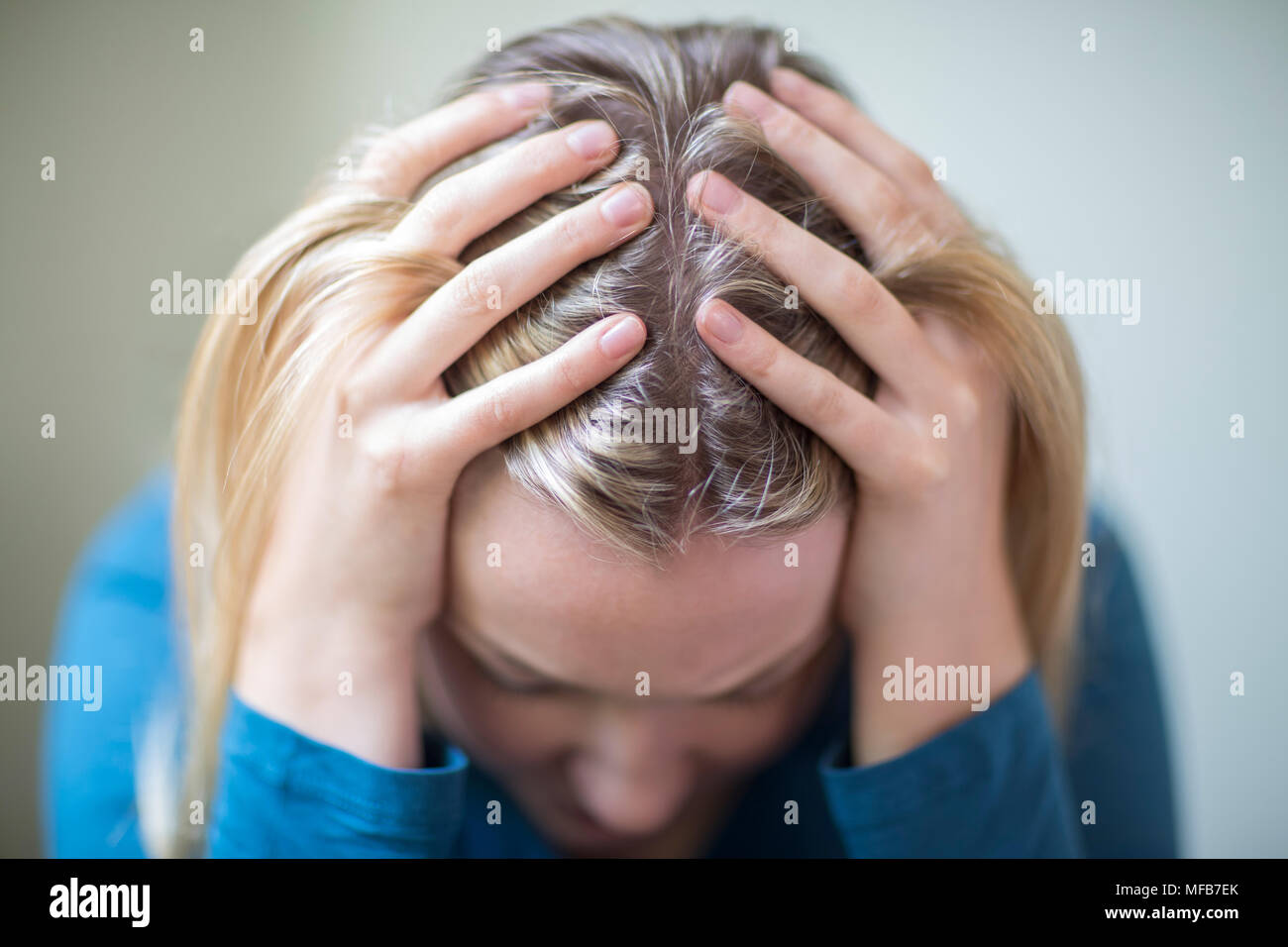 Jeune femme souffrant de dépression With Head In Hands Banque D'Images