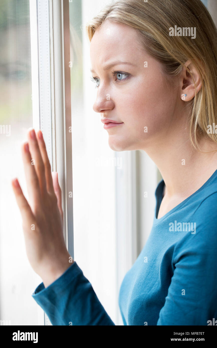 Triste jeune femme souffrant de dépression à la fenêtre de Banque D'Images