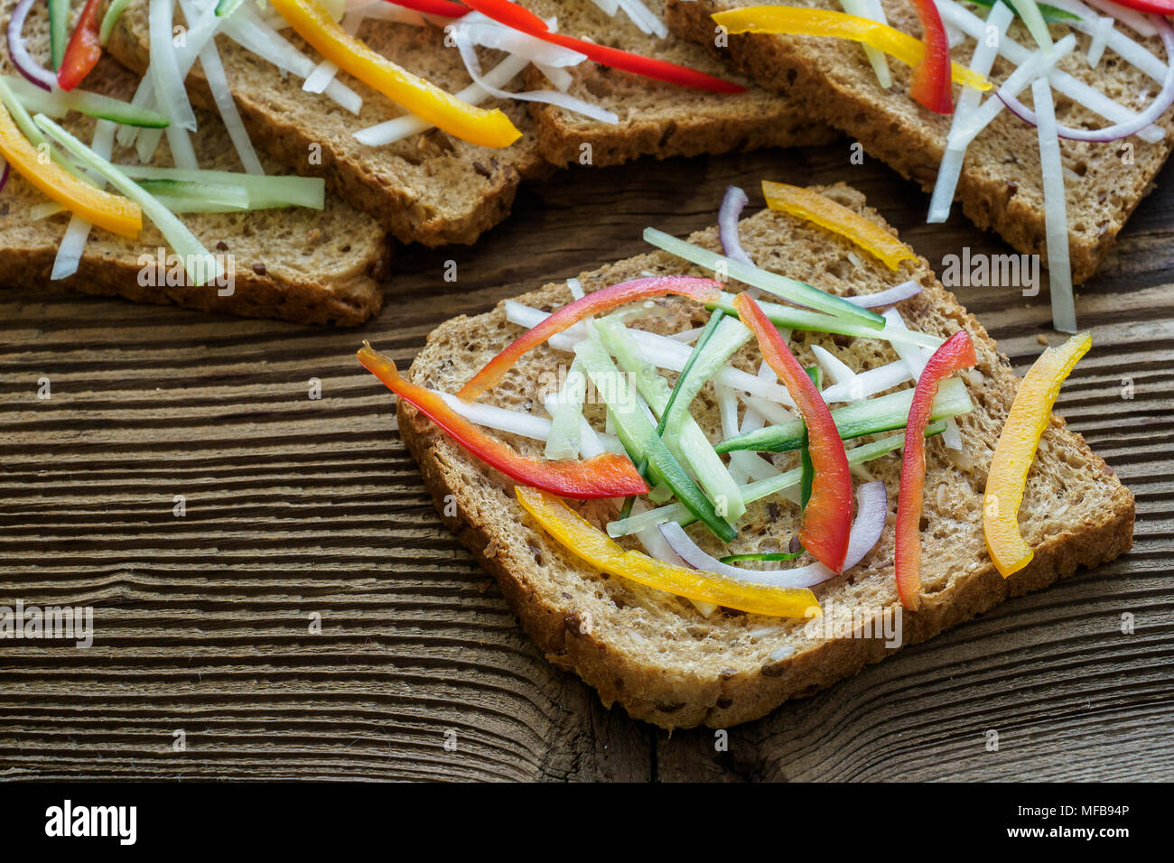 Sandwichs sains avec des légumes frais. Toasts de petit-déjeuner sur la planche à découper en bois. Petit-déjeuner équilibré. Banque D'Images