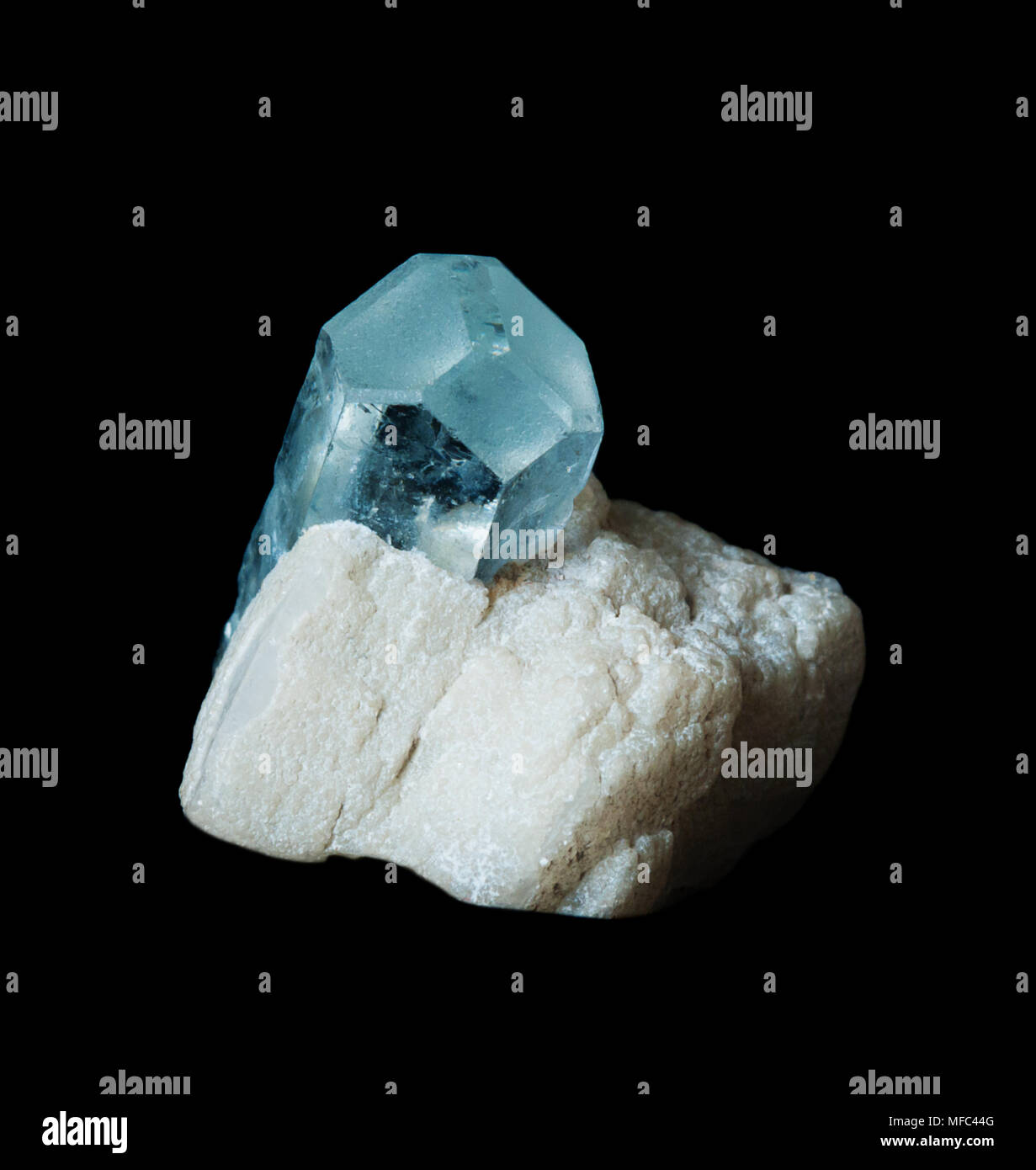 Cristal transparent bleu pierre précieuse de l'aigue-marine dans une matrice d'albite blanc, isolé sur un fond noir Banque D'Images