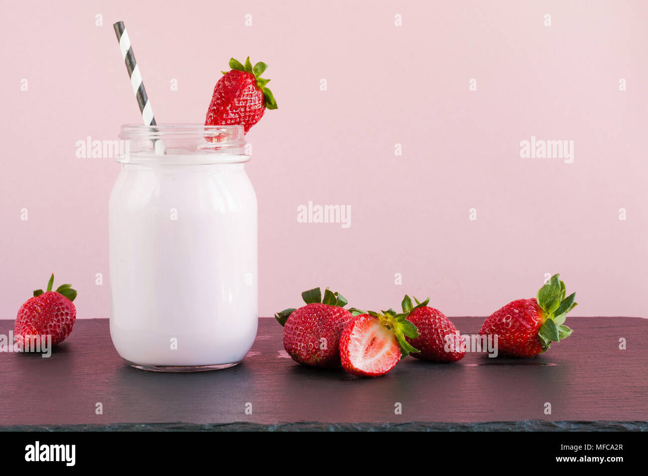 Strawberry milkshake et avec berry en pot Mason sur rose. Close up. L'alimentation d'été. Banque D'Images