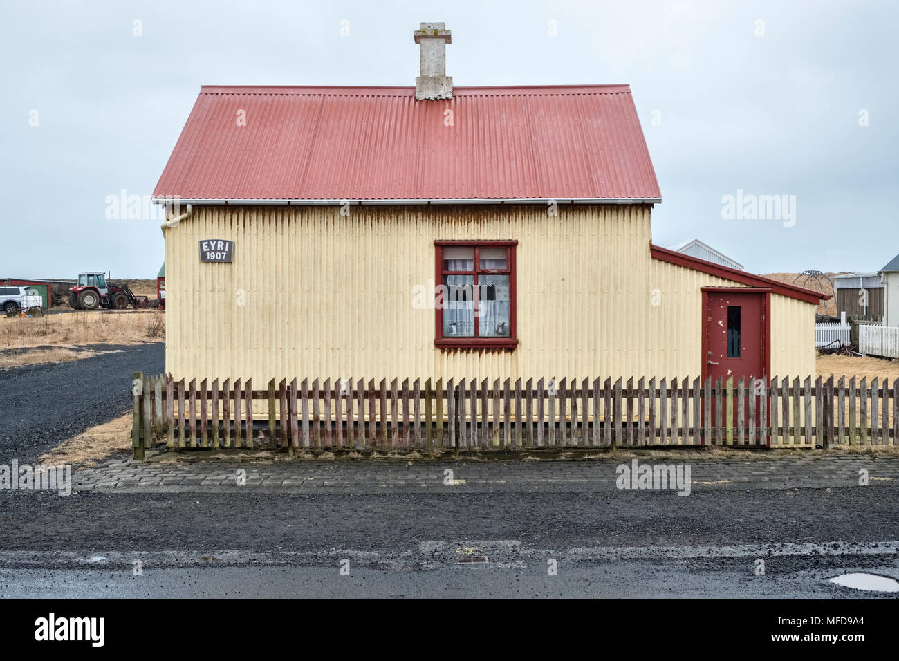 Riisa, Sud de l'Islande. Vieille typique en fer ondulé cottage avec clôture avec un signe datant de 1907 Banque D'Images