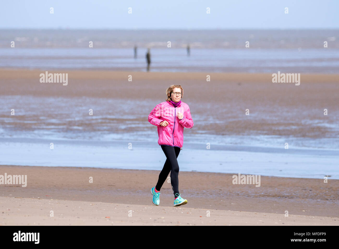 Crosby, Merseyside. 25 avril 2018. Un endroit frais et agréable de commencer la journée sur le nord-ouest de l'Angleterre comme une femme seule le jogging le long du littoral sur la plage de Crosby Beach dans le Merseyside. Credit : Cernan Elias/Alamy Live News Banque D'Images