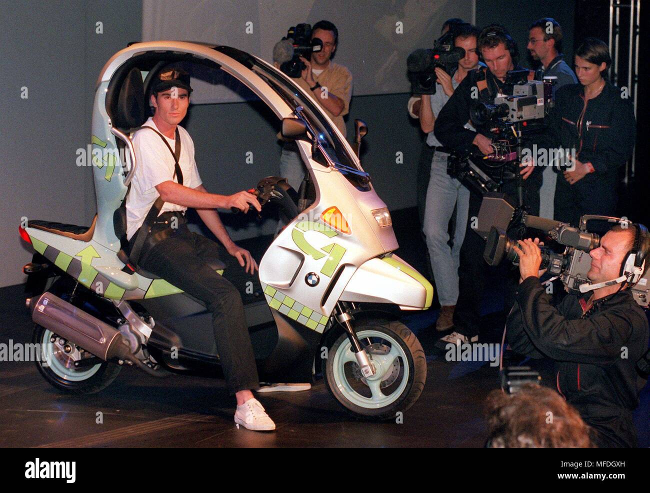 Réaménagé par les cameramen et photographes, l'entreprise automobile BMW va montrer son modèle C 1 le 8 septembre 1997 à l'approche de l'International Motor Show (IAA). Les deux-roues, un tableau blanc trafic entrera en production en série à la fin de 1999 et sera lancée au printemps de 2000. Le lecteur est un moteur monocylindrique avec 125 centimètres cubes de déplacement et d'environ 11 kW/15 CH. Dawith appartient à la C1 sur le plan juridique, de la Leichtkraftradern, peut aussi être conduit par les titulaires d'un permis de conduire voiture, qui a été acquis avant le 1er avril 1980. La ville-mobile est d'environ 2,15 m de lon Banque D'Images