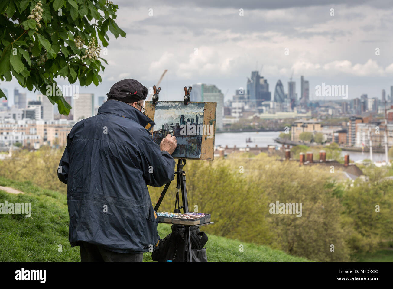 Londres, Royaume-Uni. 25 avril, 2018. Météo France : un bon artiste peint le paysage de ville, y compris le Gherkin et Cheesegrater bâtiments de Greenwich Park sur un ciel nuageux l'après-midi. Crédit : Guy Josse/Alamy Live News Banque D'Images