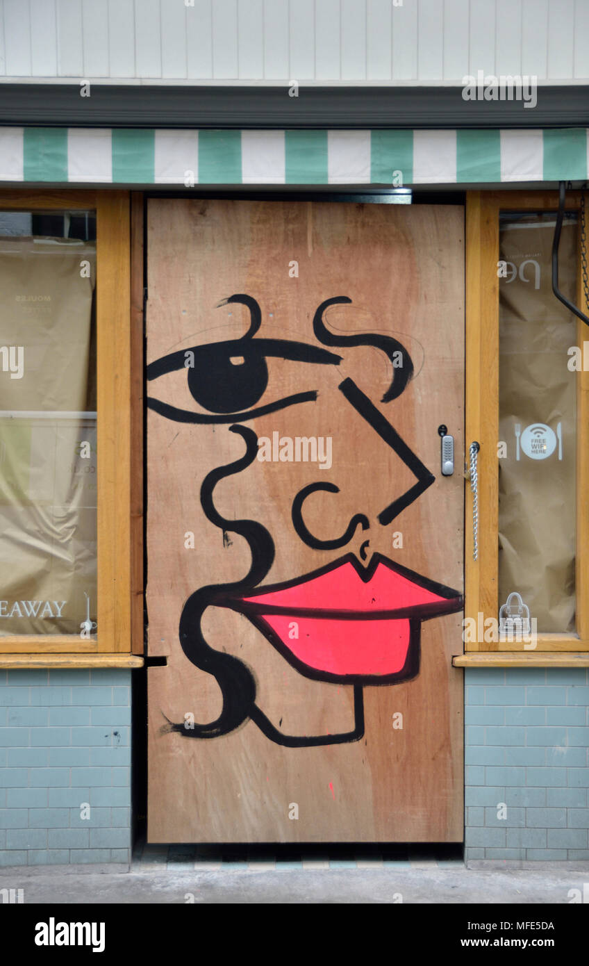 Un dessin d'un visage sur un magasin porte. Banque D'Images