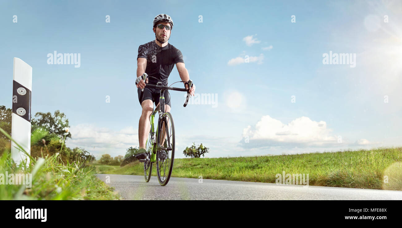 Un cycliste sur route ensoleillée Banque D'Images