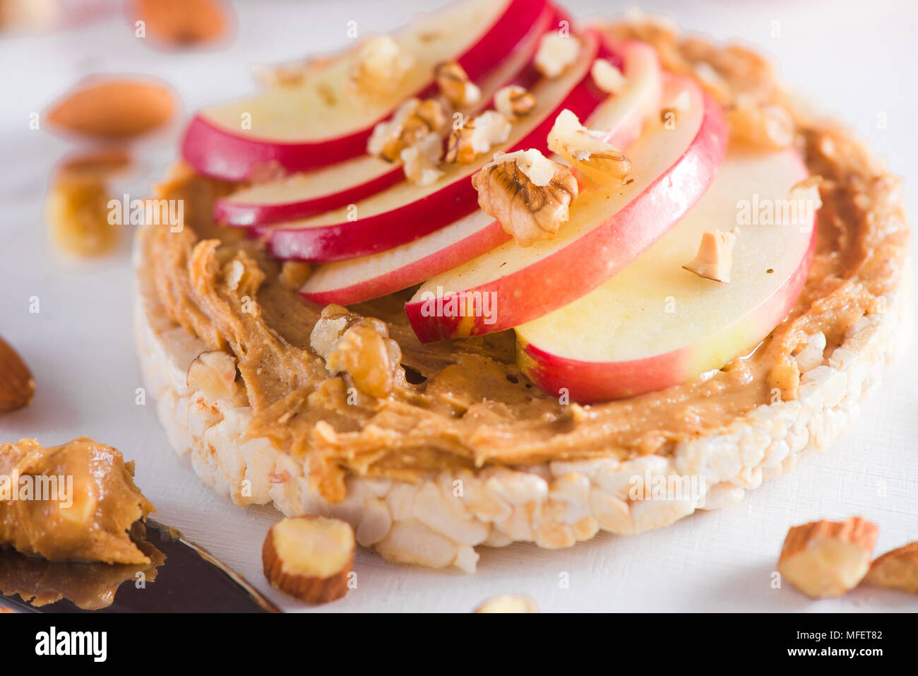 Toast de pain croustillant aux pommes avec des tranches de pomme, beurre de cacahuètes, amandes et noix. Petit-déjeuner sain dans un concept clé. Banque D'Images