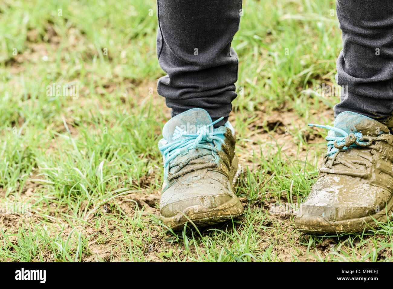 Sur un terrain humide dans la campagne de l'Angleterre East Midlands, un malheureux enfant a brouillé les chaussures bleu qui sont sa fierté et de joie. Banque D'Images