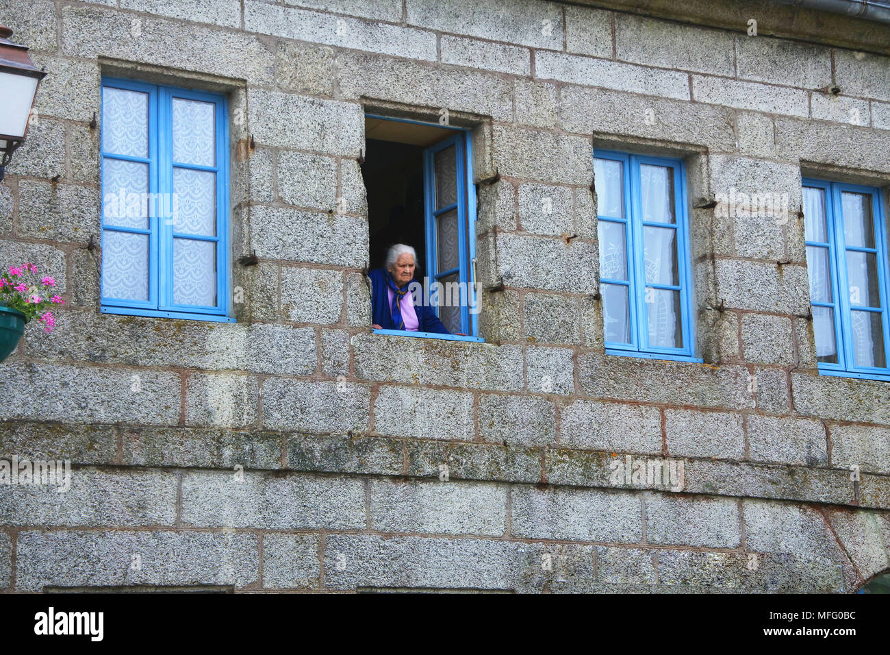Vieille dame à la fenêtre de sortie, Huelgoat, Bretagne, France - John Gollop Banque D'Images