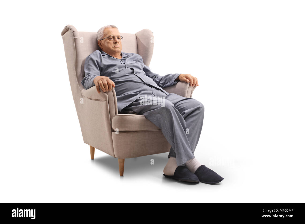 Grumpy Old man en pyjama assis dans un fauteuil isolé sur fond blanc Banque D'Images