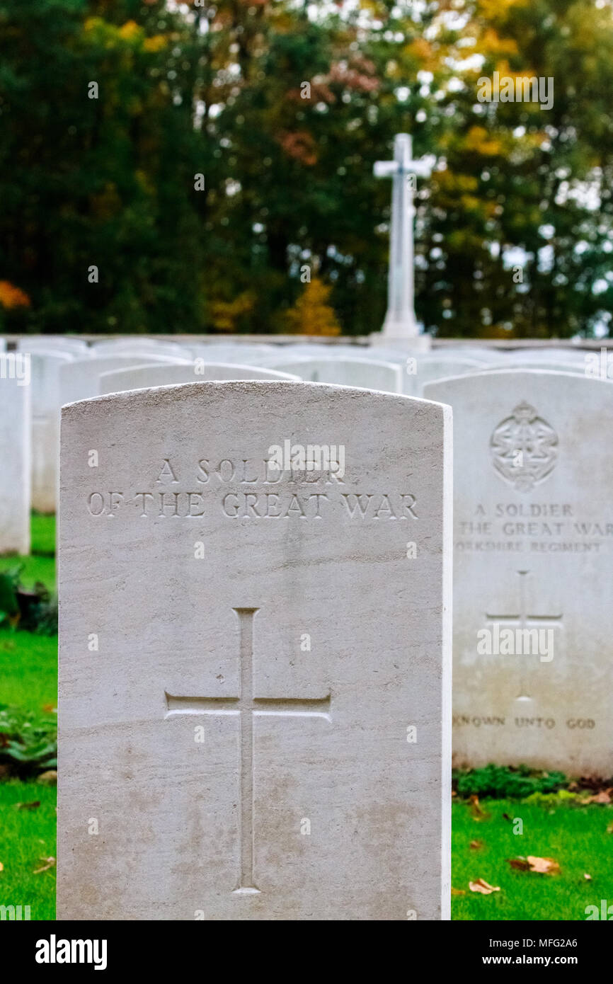 Tombe d'un soldat de la Grande Guerre en Commonwealth War Graves Commission (CWGC) Bois du Sanctuaire cimetière avec un cénotaphe à l'arrière-plan. Banque D'Images