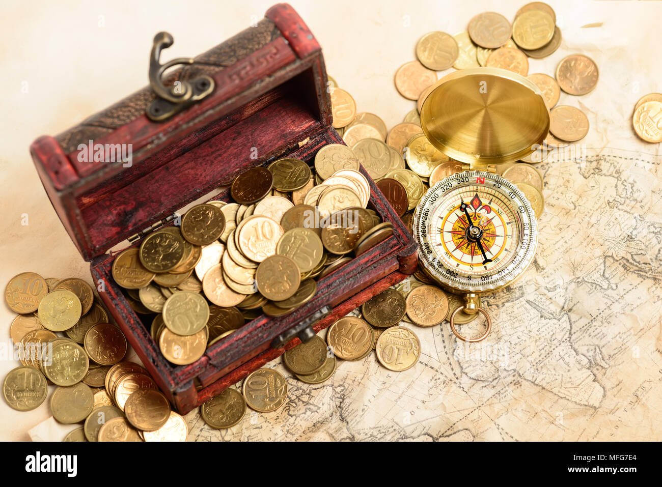 Ouvrir coffre au trésor rempli de pièces de couleur d'or et de la boussole sur la carte du monde médiéval Banque D'Images
