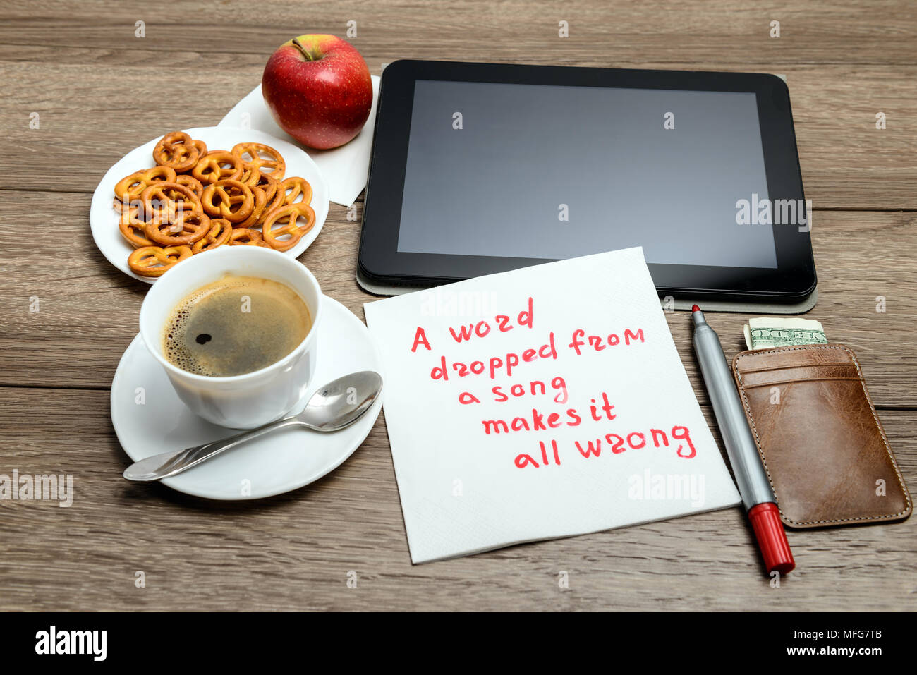Message de l'écriture de serviette sur proverbe table en bois avec du café, de la nourriture et tablet PC un mot tombé de une chanson fait tout faux Banque D'Images