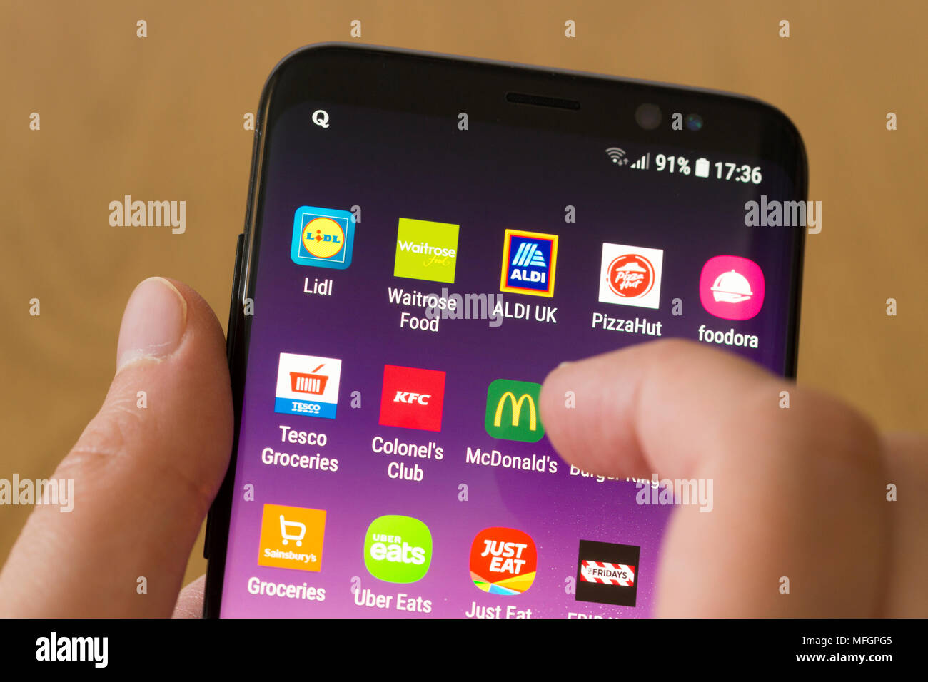 Une femme en sélectionnant le McDonald's app sur un smartphone Banque D'Images
