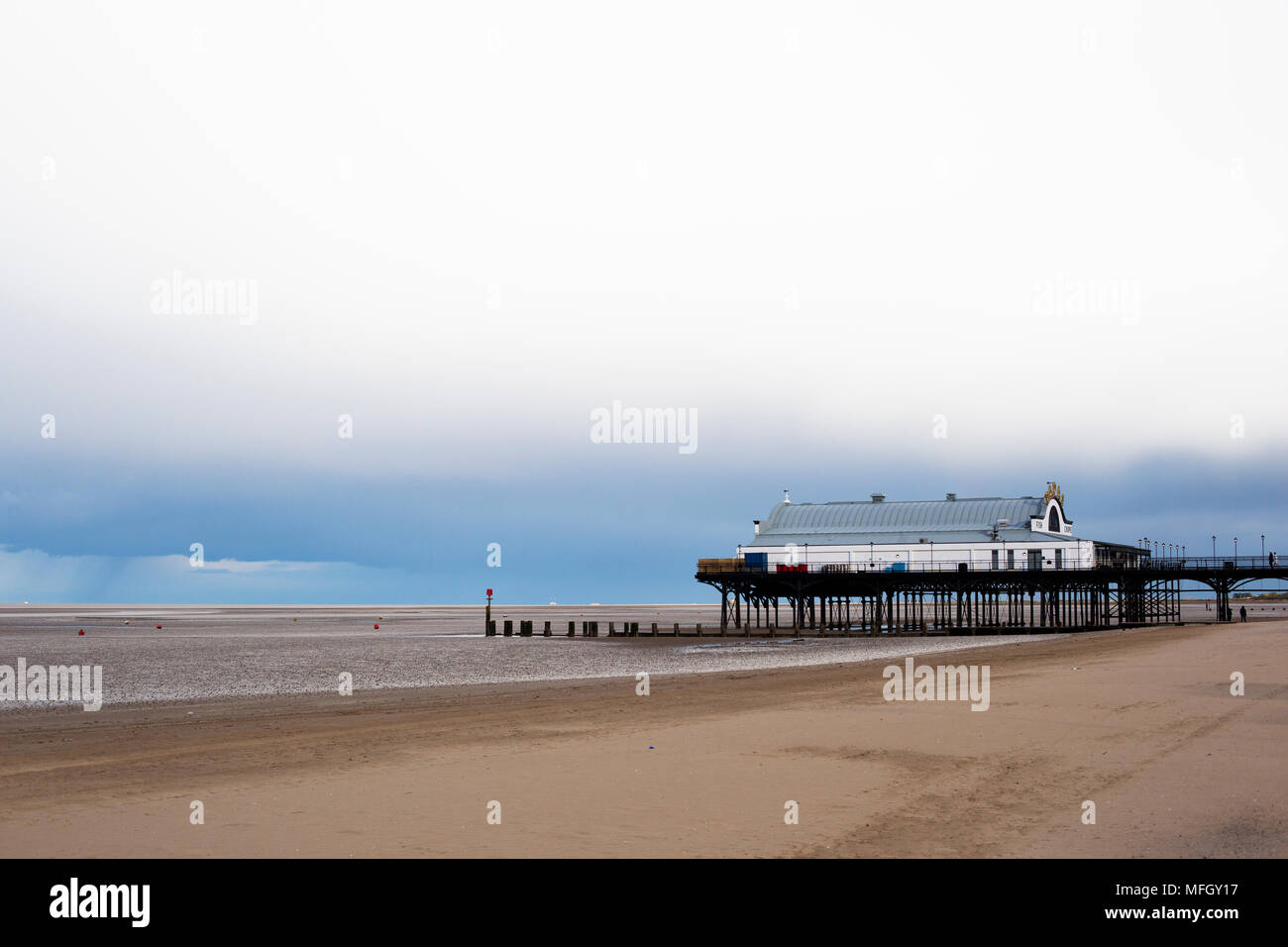 Cleethorpes Pier à marée basse avec un ciel couvert en format paysage. Banque D'Images