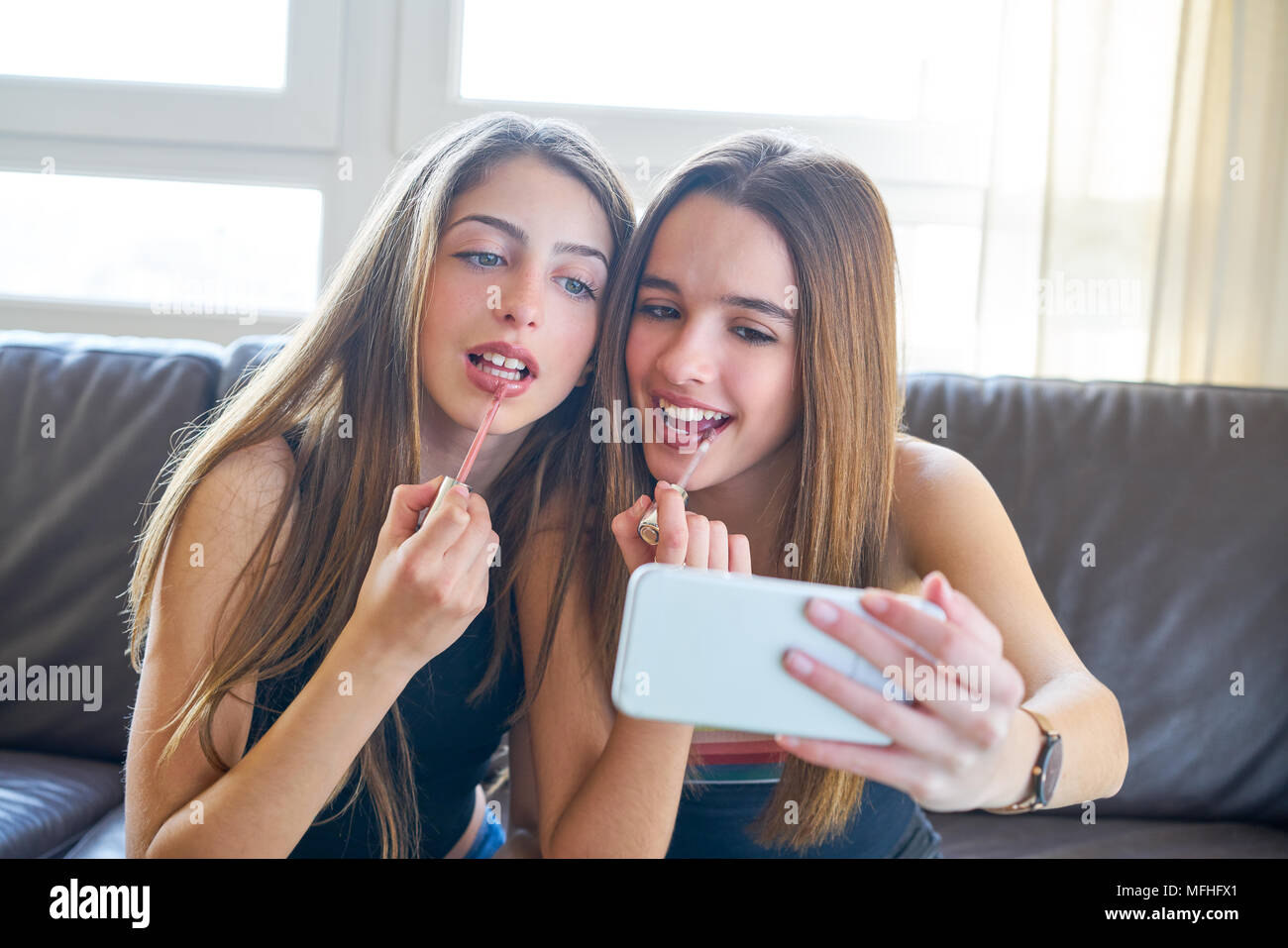 Adolescent Girls best friends un miroir de l'appareil photo du smartphone en selfies make-up Banque D'Images