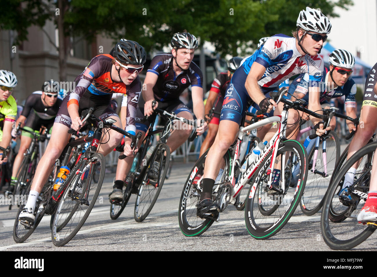 Un groupe d'hommes étroitement serrées les cyclistes se pencher dans un virage pendant la course dans une course amateur à Athens, Géorgie le 25 avril 2015. Banque D'Images