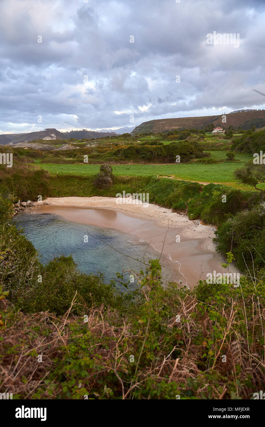 Coucher de soleil sur la plage de Gulpiyuri, qui est une plage intérieure, s'est produite dans un gouffre inondé créé par l'érosion karstique (mer de Cantabrian, Naves, Llanes, Asturies, Espagne) Banque D'Images