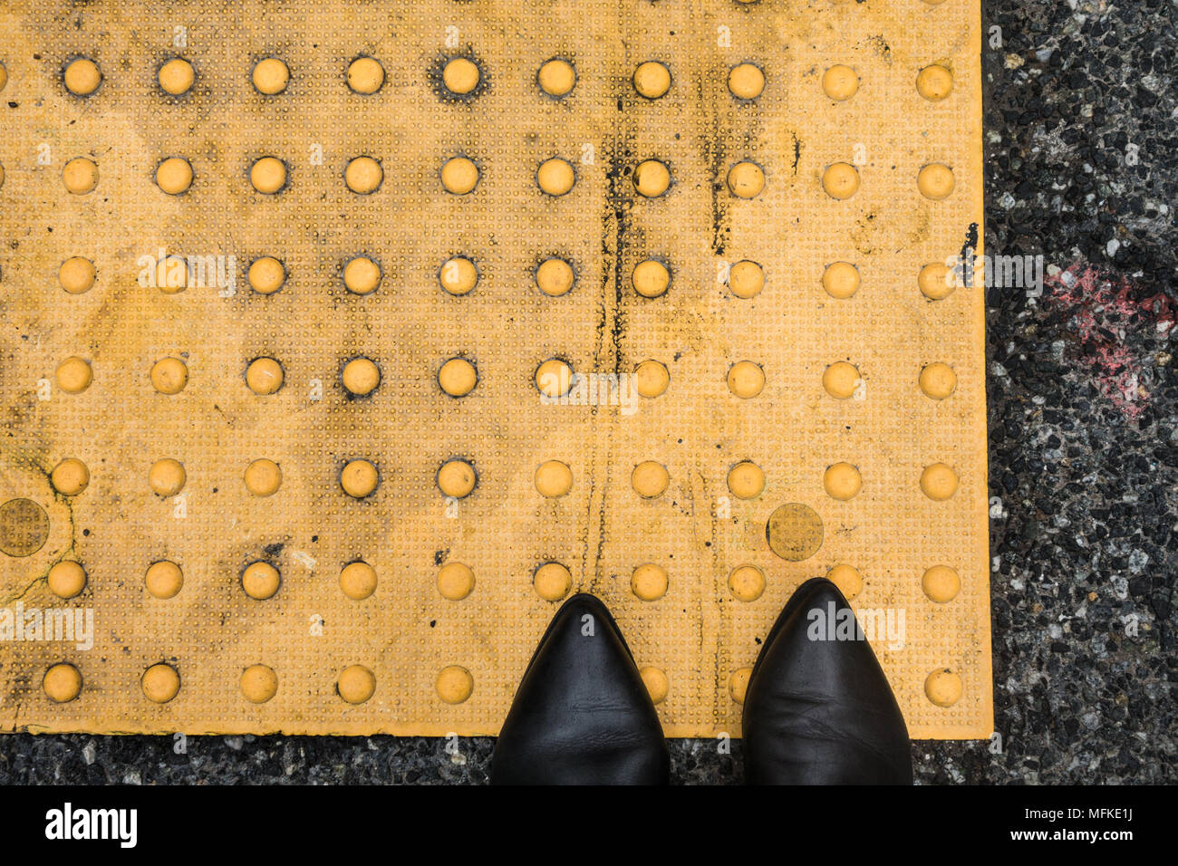 Deux platines debout sur un trottoir de la voie de sécurité jaune Banque D'Images