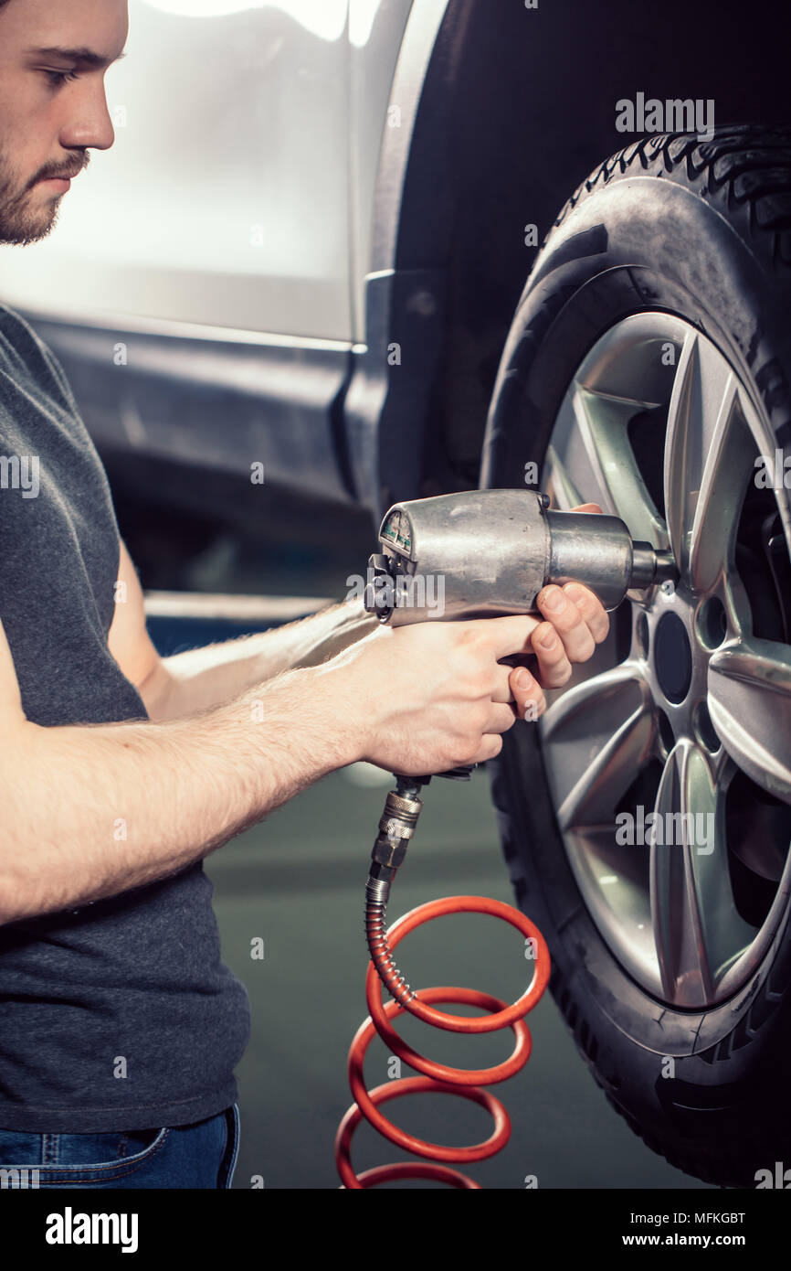 Changer de mécanicien sur roue voiture avec outil pneumatique Photo Stock -  Alamy