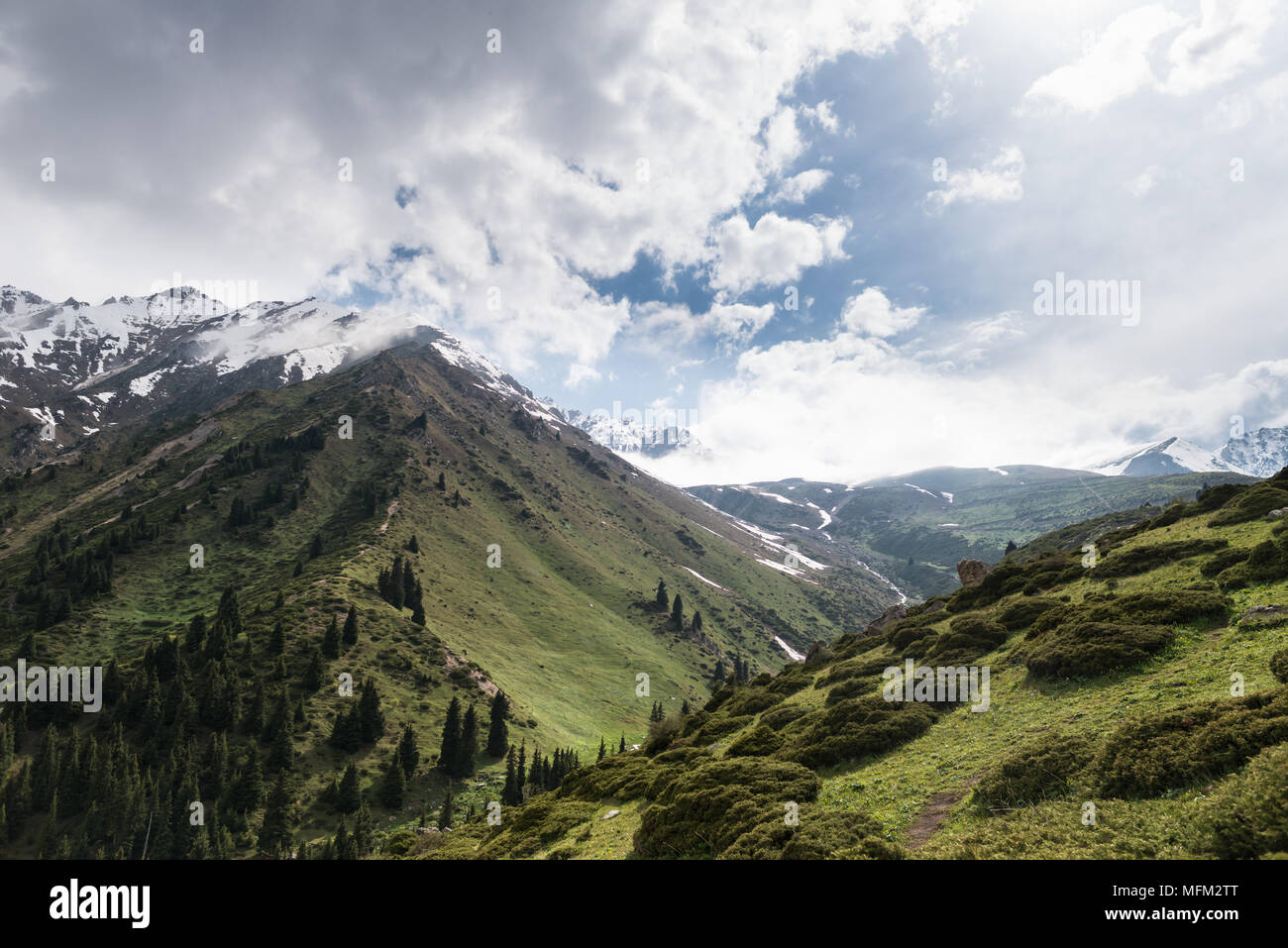 Vue panoramique sur les montagnes majestueuses et de cimes enneigées. Beau ciel nuageux spectaculaires. Région du sud du Kazakhstan. Banque D'Images