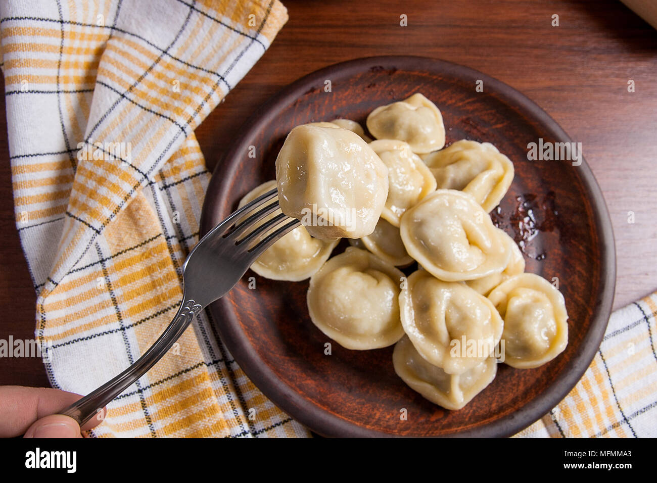 Vue rapprochée de la viande bouillie des dumpling sur fourchette métallique et servi dans la plaque d'argile quenelles avec sauce crémeuse et fourchette métallique. La composition à rusti Banque D'Images