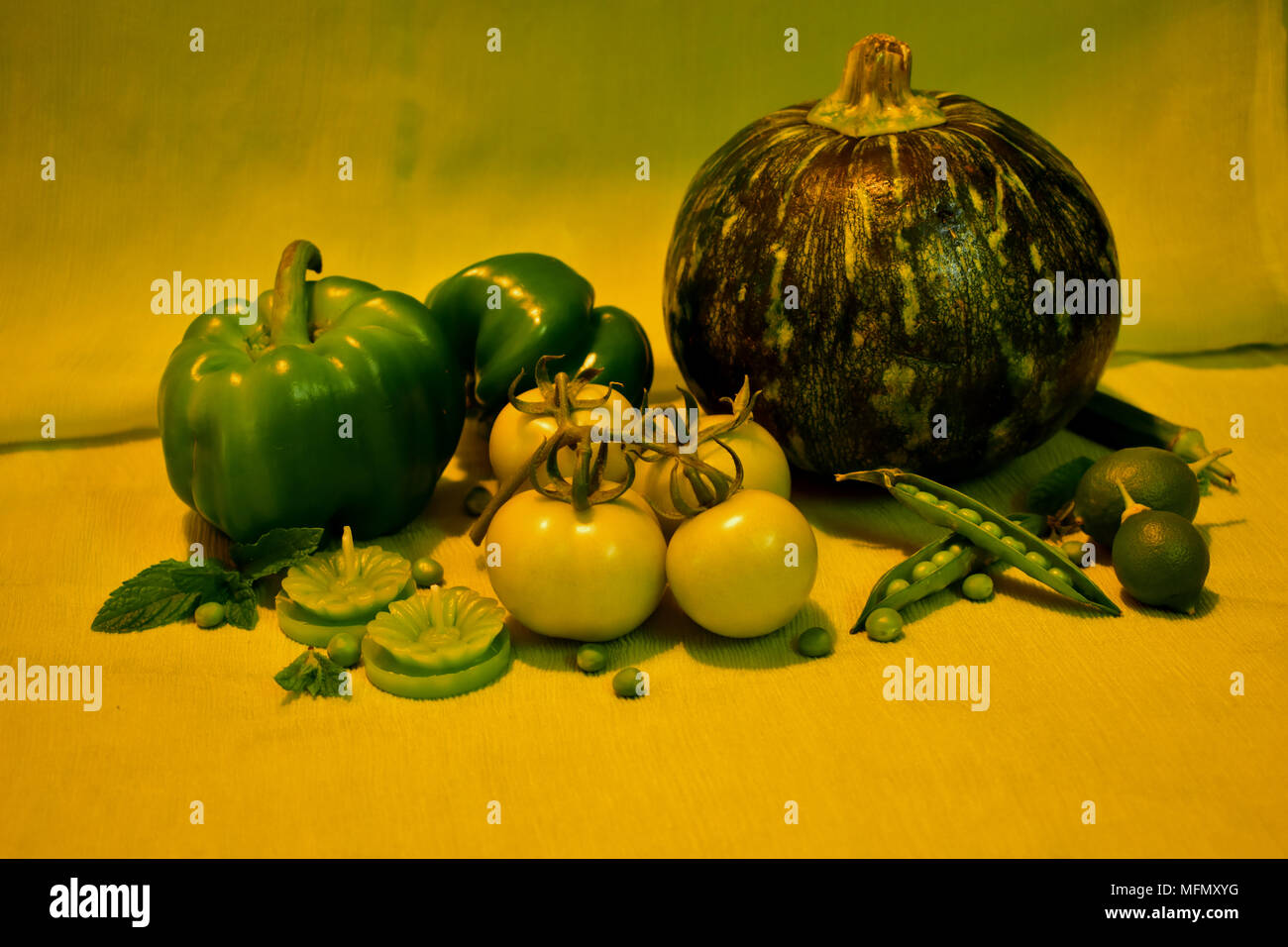 La vie toujours avec des légumes verts : capsicum, tomates, courgettes, petits pois, citrons, ladyfinger, feuilles de menthe et des bougies. Banque D'Images