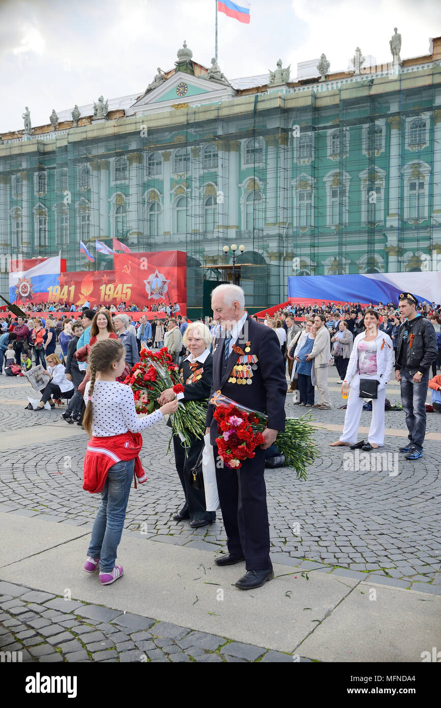 La jeune fille donne des fleurs à l'ancien combattant de la Seconde Guerre mondiale, la Place du Palais, Saint Petersburg, Russie Banque D'Images