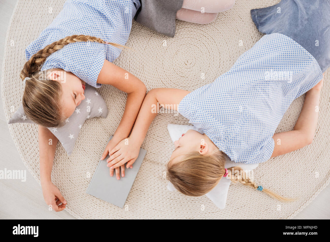 Vue de dessus de lits, les jeunes filles s'allonger sur un tapis en osier, tenant les mains, parler des problèmes et de soutenir les uns les autres Banque D'Images