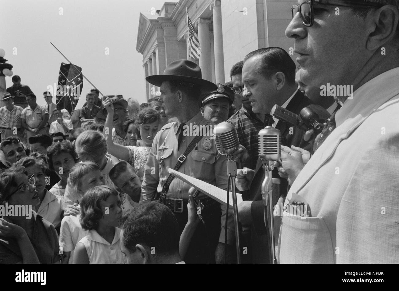 Little Rock, USA, 1959. Rassemblement au State Capitol. La photographie montre un groupe de personnes, l'un tenant un drapeau confédéré, entourant des haut-parleurs et de la Garde nationale, pour protester contre l'admission de la 'Little Rock Nine' à Central High School. 20 août 1959. Photographe : John T Bledsoe. Banque D'Images