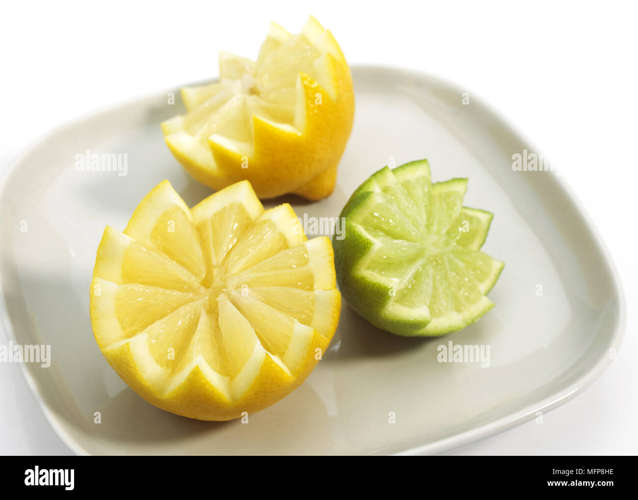 La plaque avec le jaune citron, Citrus limonum et vert citron, Citrus aurantifolia Banque D'Images