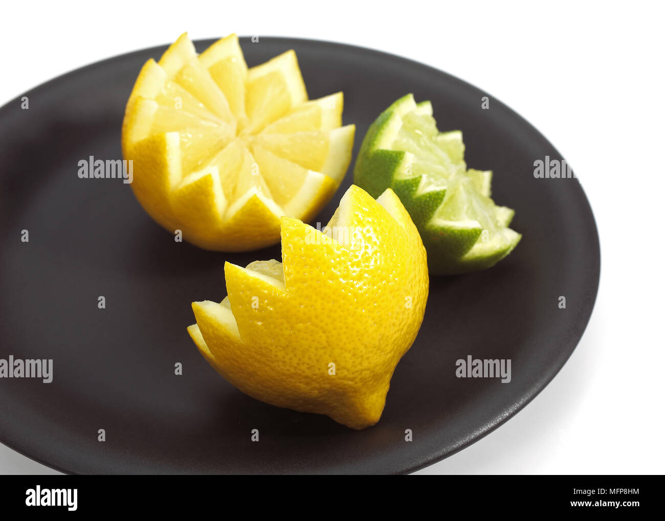 La plaque avec le jaune citron, Citrus limonum et vert citron, Citrus aurantifolia Banque D'Images