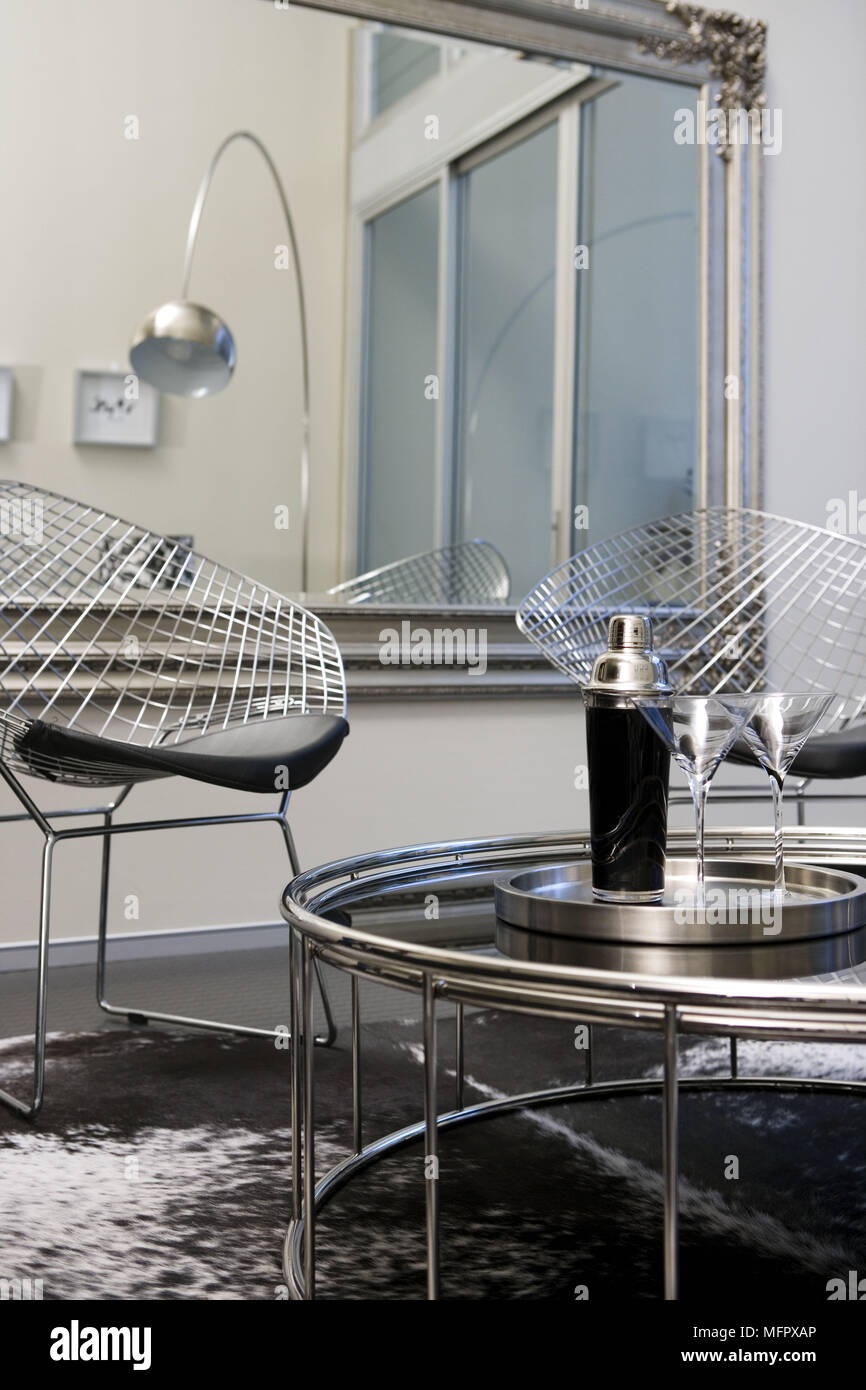 Table basse en acier en face de paire de chaises Harry Bertoia dans salon moderne Banque D'Images