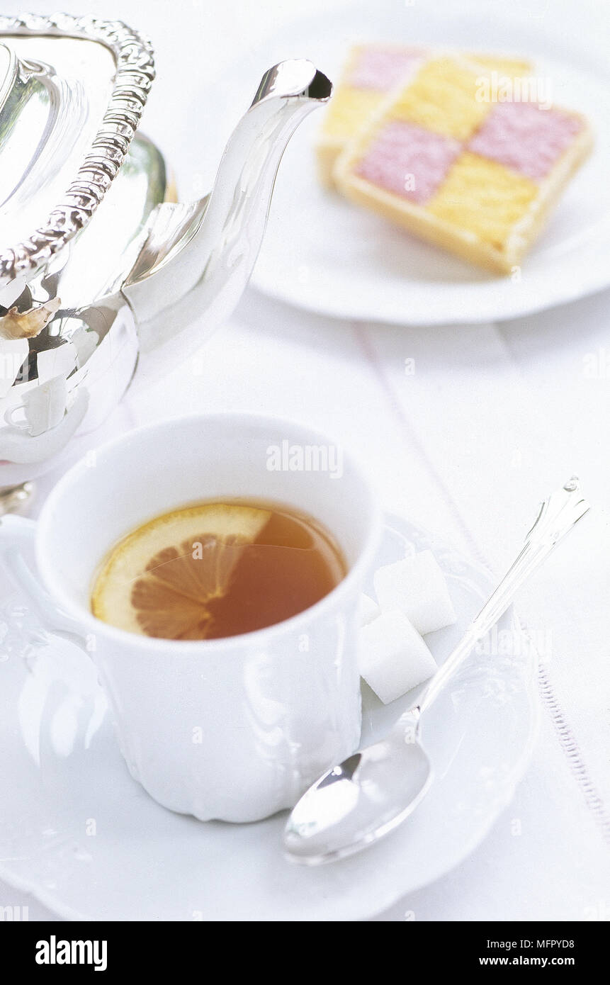 Thé au citron et une tranche de gâteau de battenberg Banque D'Images